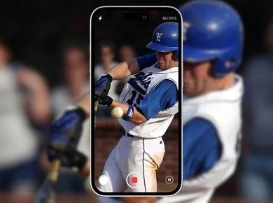 A baseball player with a blue helmet and uniform hitting a baseball, with the scene framed inside a smartphone screen.